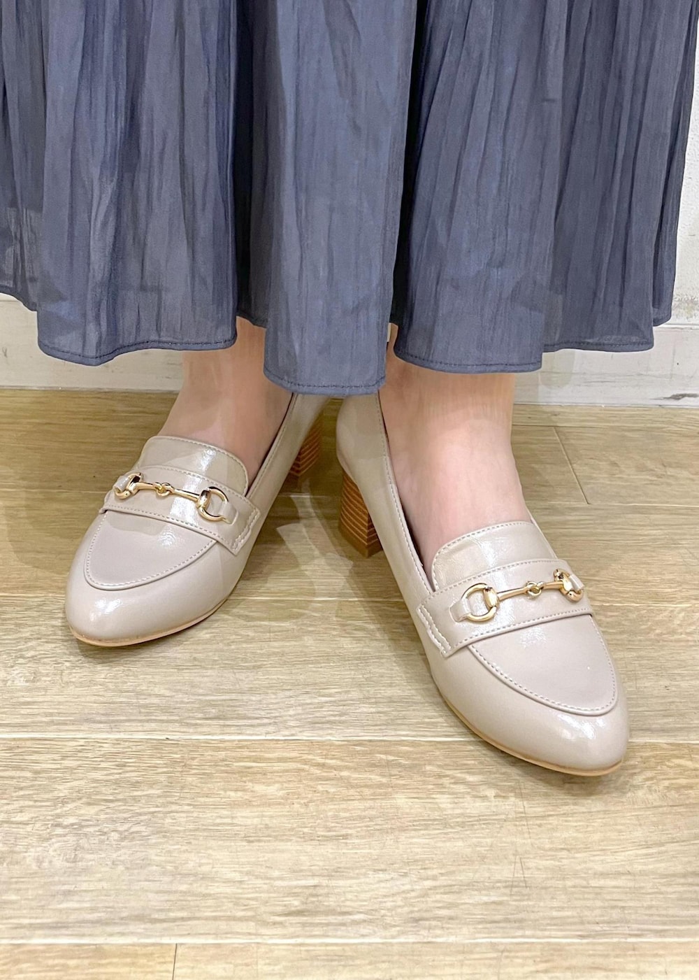 ブルー系のスカート、ベージュ系のローファー、ホワイト系のショルダーバッグを着用したレディースの冬コーディネートの10枚目の写真