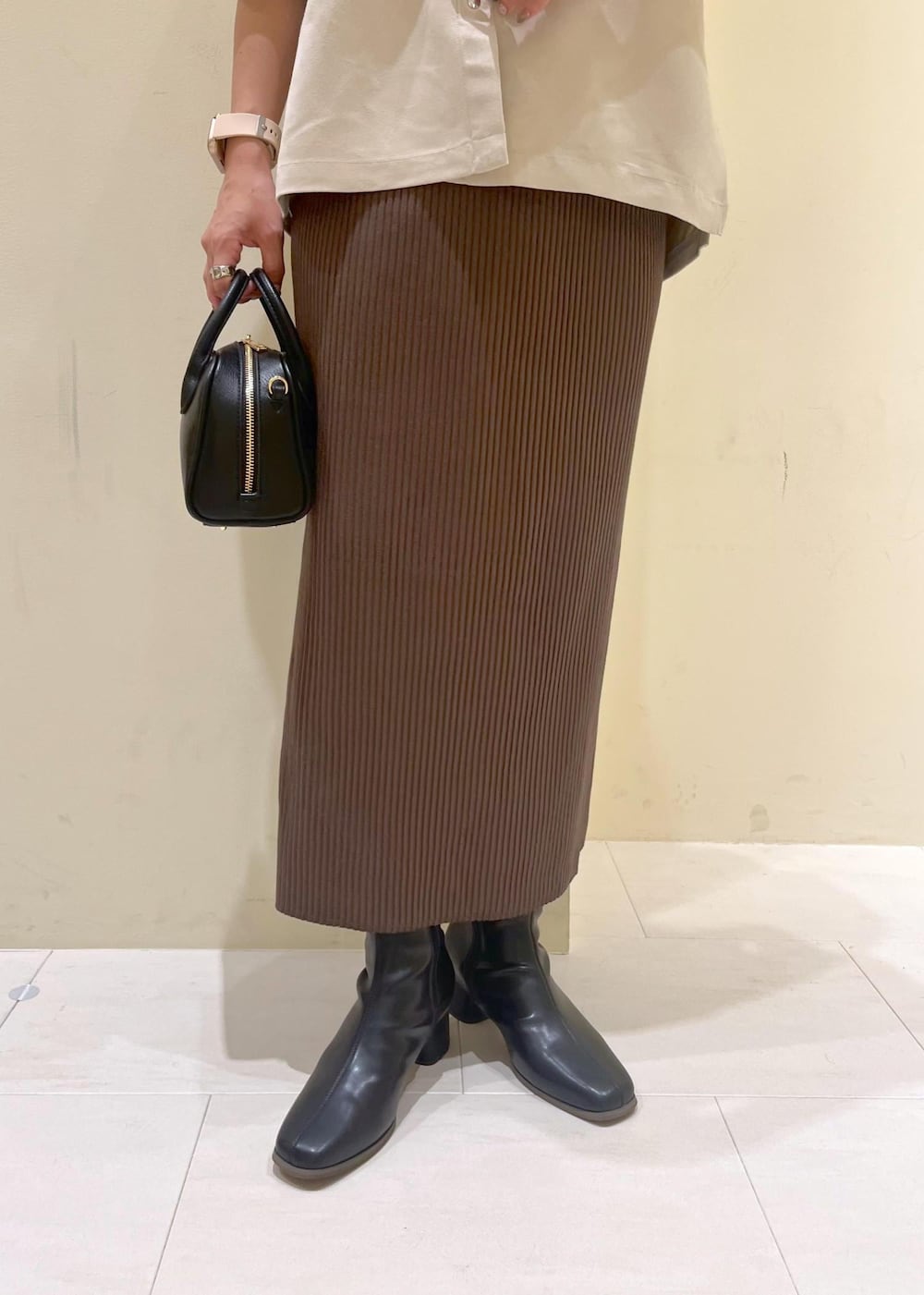 ベージュ系のシャツ/ブラウス、ブラック系のブーツ、グリーン系のスカートを着用したレディースの秋コーディネートの6枚目の写真