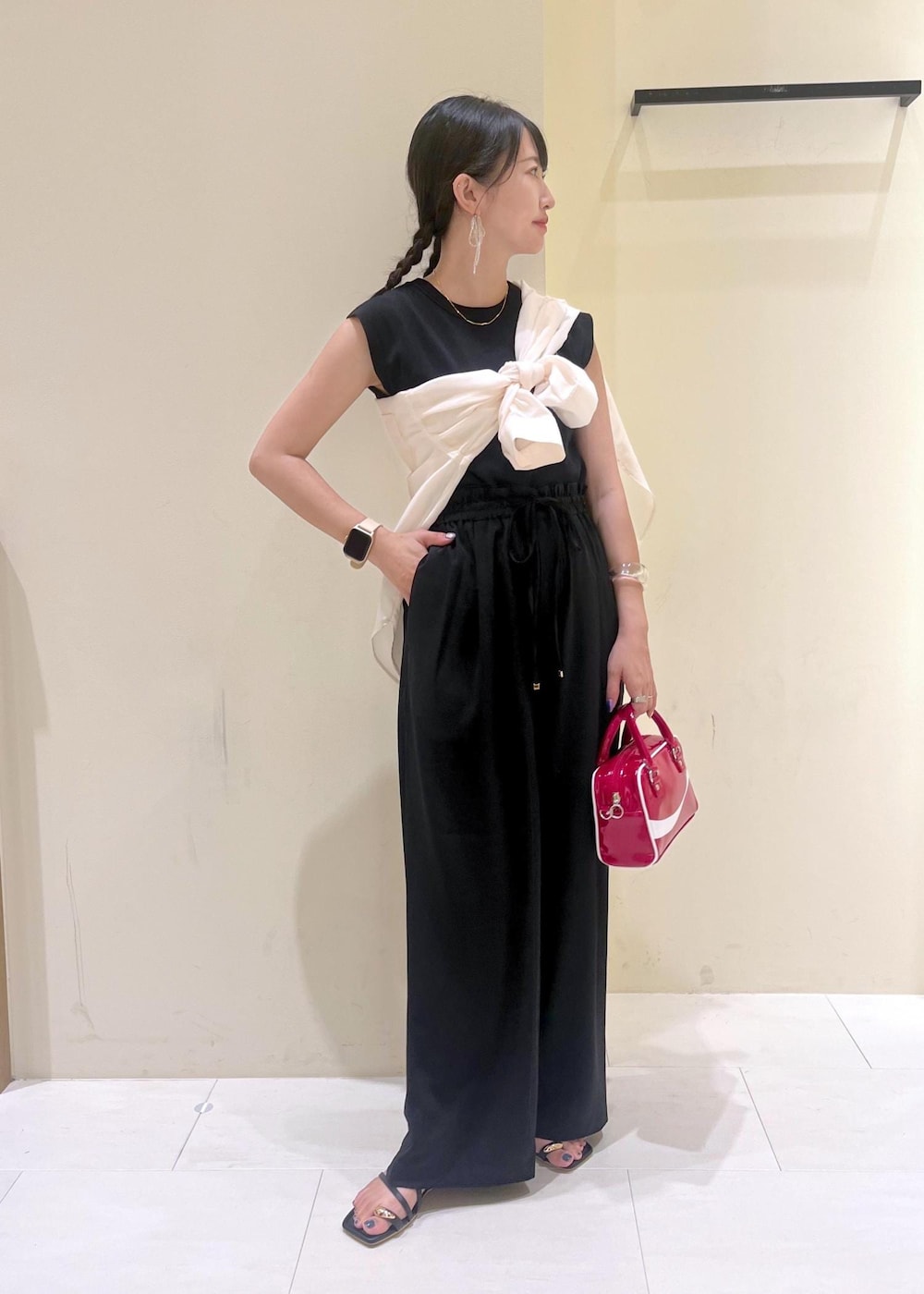 ブラック系のニット/セーター、ホワイト系のシャツ/ブラウス、ブラック系のサンダルを着用したレディースの夏コーディネートの2枚目の写真