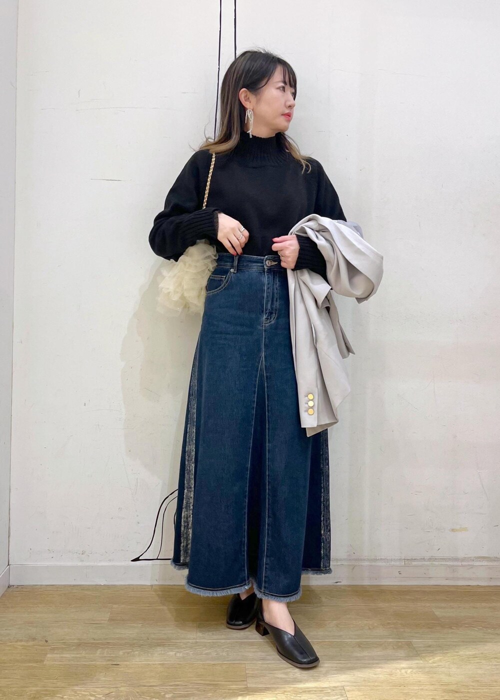 ブラック系のニット/セーター、ブラック系のニット/セーター、ブルー系のデニムスカートを着用したレディースの冬コーディネートの8枚目の写真