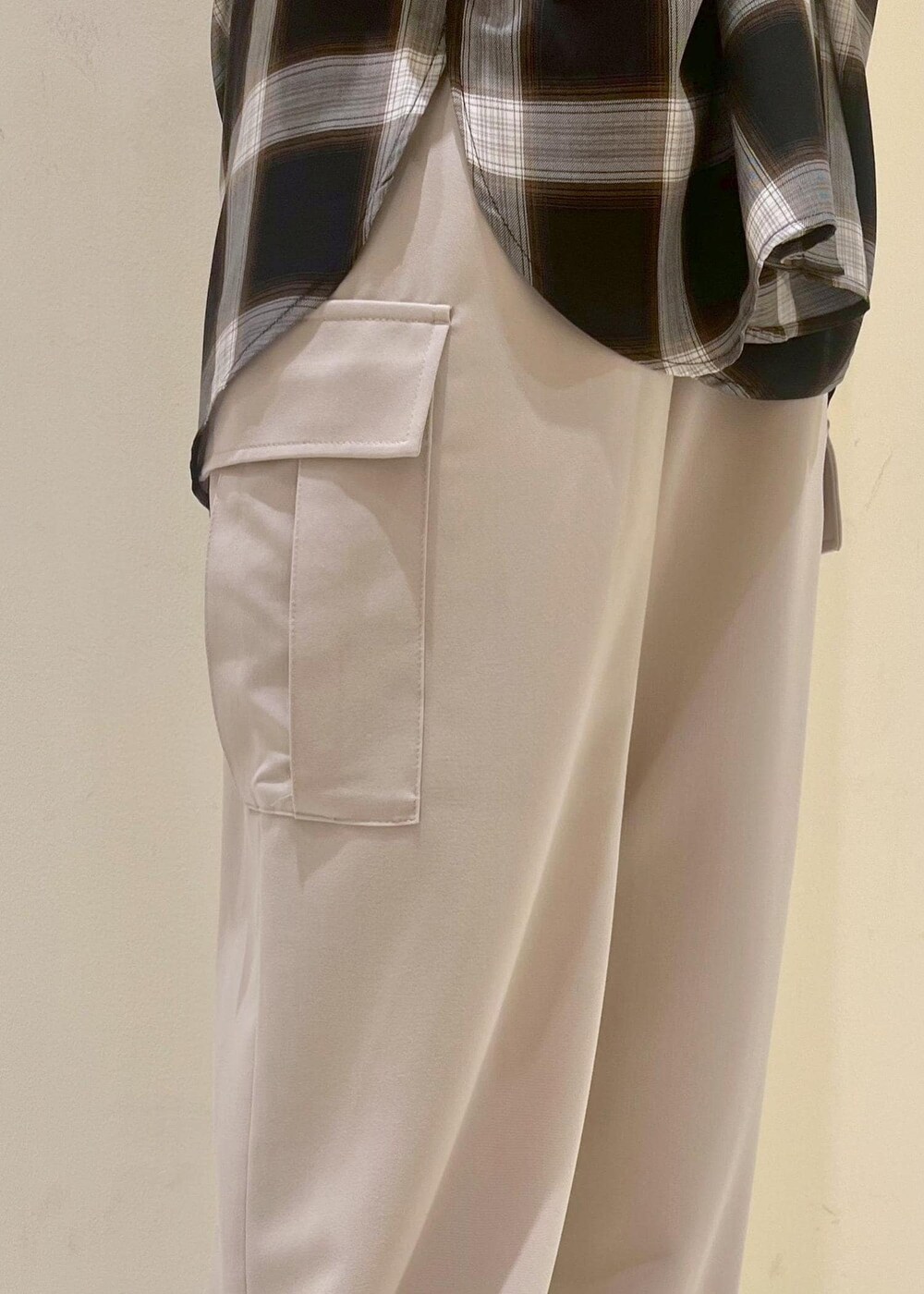 ブラック系のニット/セーター、ベージュ系のカーゴパンツ、ブラウン系のサンダルを着用したレディースの夏コーディネートの8枚目の写真