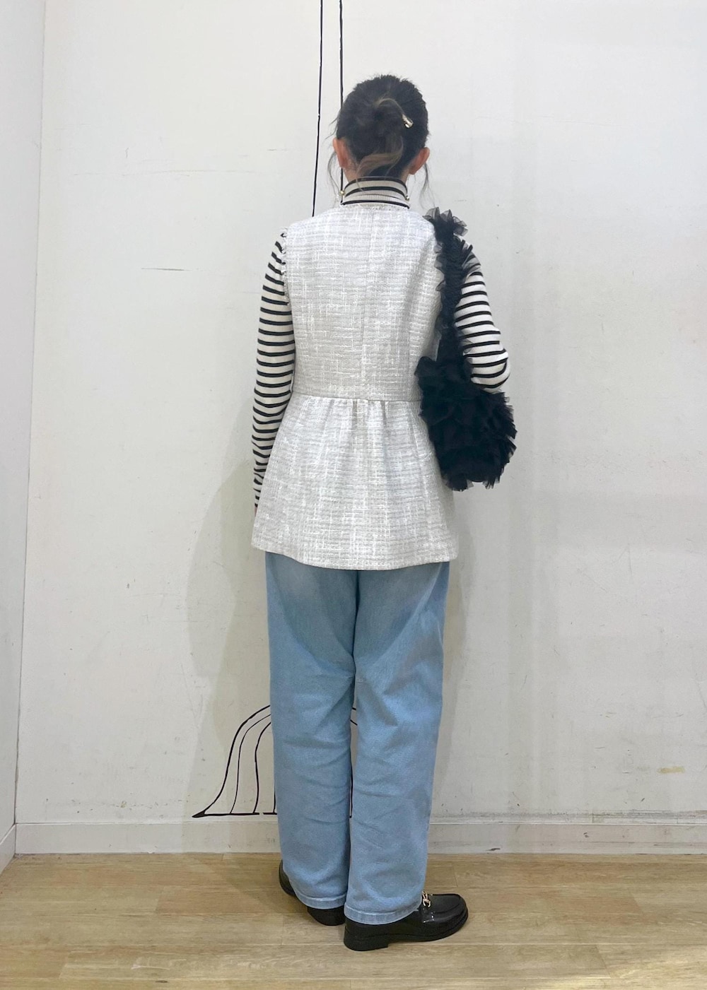 ホワイト系のニット/セーター、ブルー系のデニムパンツ、ブラック系のレインシューズを着用したレディースの冬コーディネートの5枚目の写真