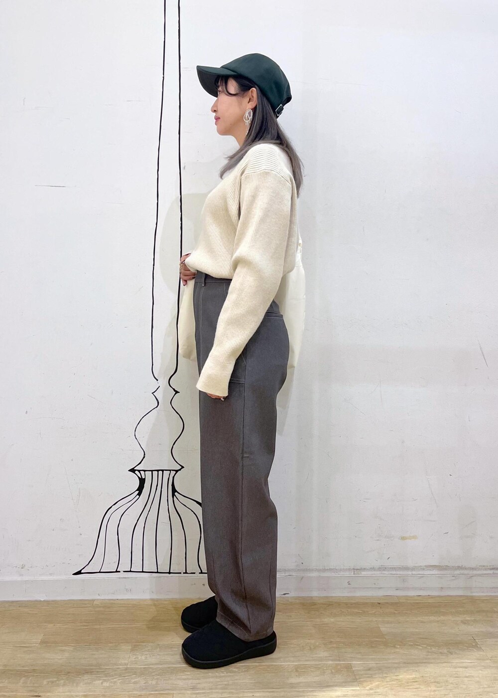 ベージュ系のニット/セーター、ホワイト系のトートバッグ、ブラック系のスリッポンを着用したレディースの冬コーディネートの2枚目の写真