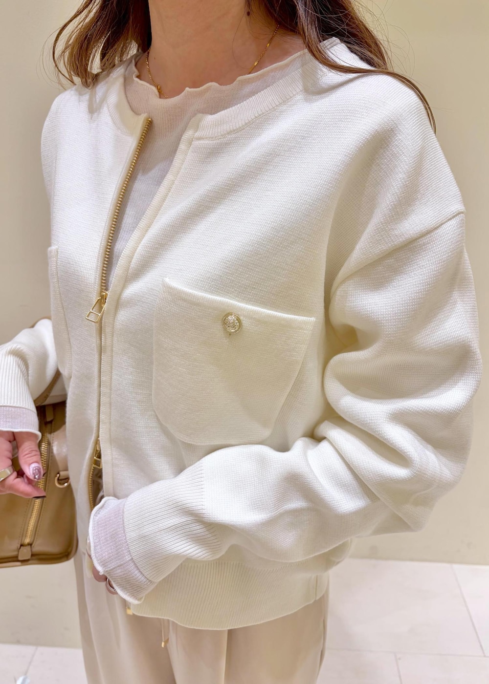 ホワイト系のTシャツ/カットソー、イエロー系のローファー、ベージュ系のボストンバッグを着用したレディースの冬コーディネートの7枚目の写真