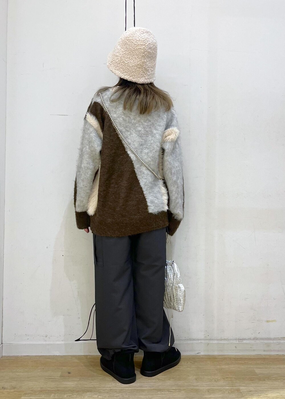 グレー系のカーゴパンツ、シルバー系のショルダーバッグ、ブラウン系のニット/セーターを着用したレディースの秋コーディネートの4枚目の写真