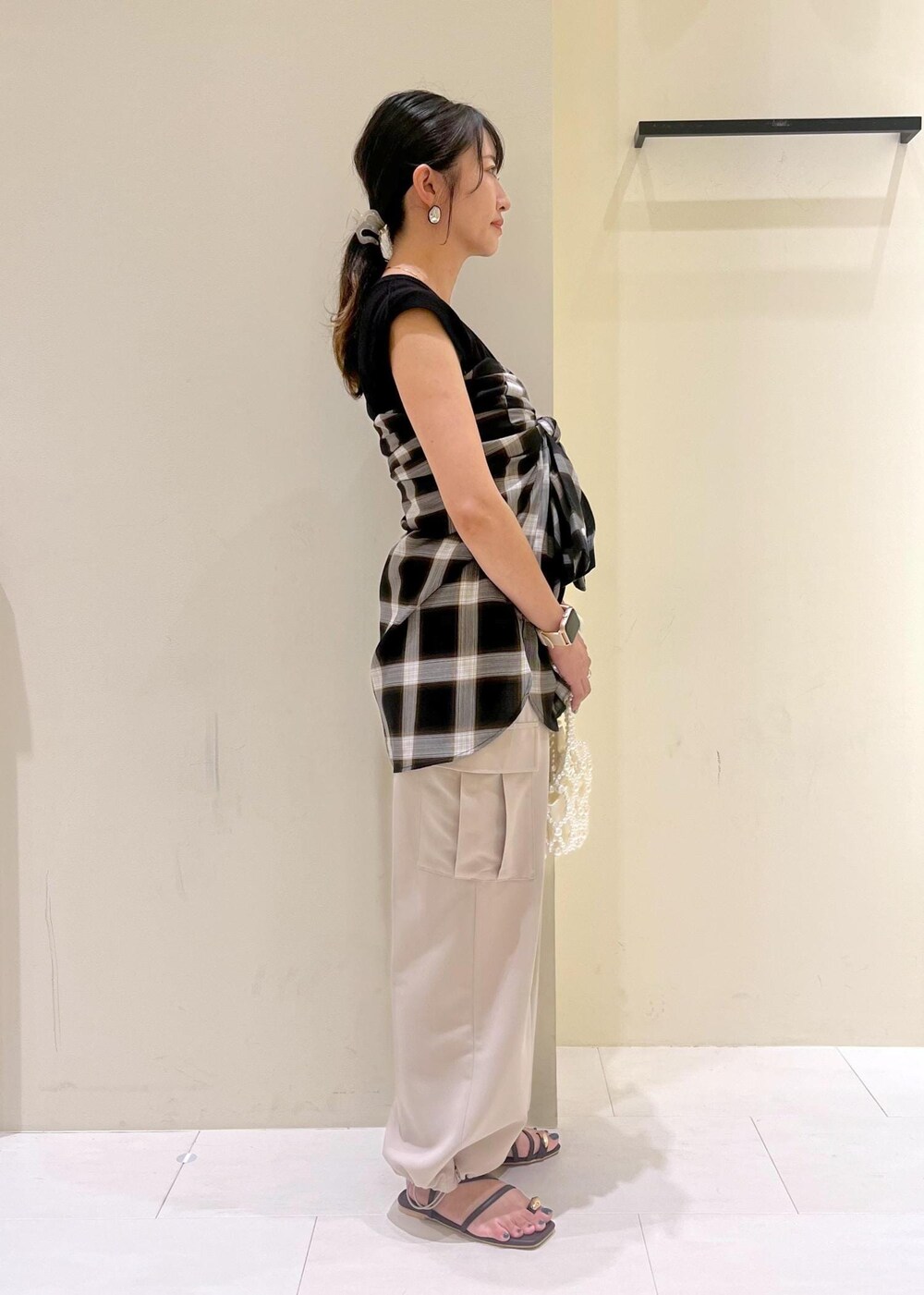 ブラック系のニット/セーター、ベージュ系のカーゴパンツ、ブラウン系のサンダルを着用したレディースの夏コーディネートの3枚目の写真