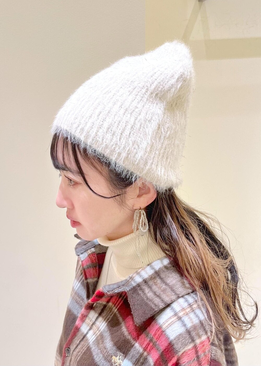 ブラック系のブーツ、ホワイト系のニット/セーター、シルバー系のハンドバッグを着用したレディースの冬コーディネートの4枚目の写真