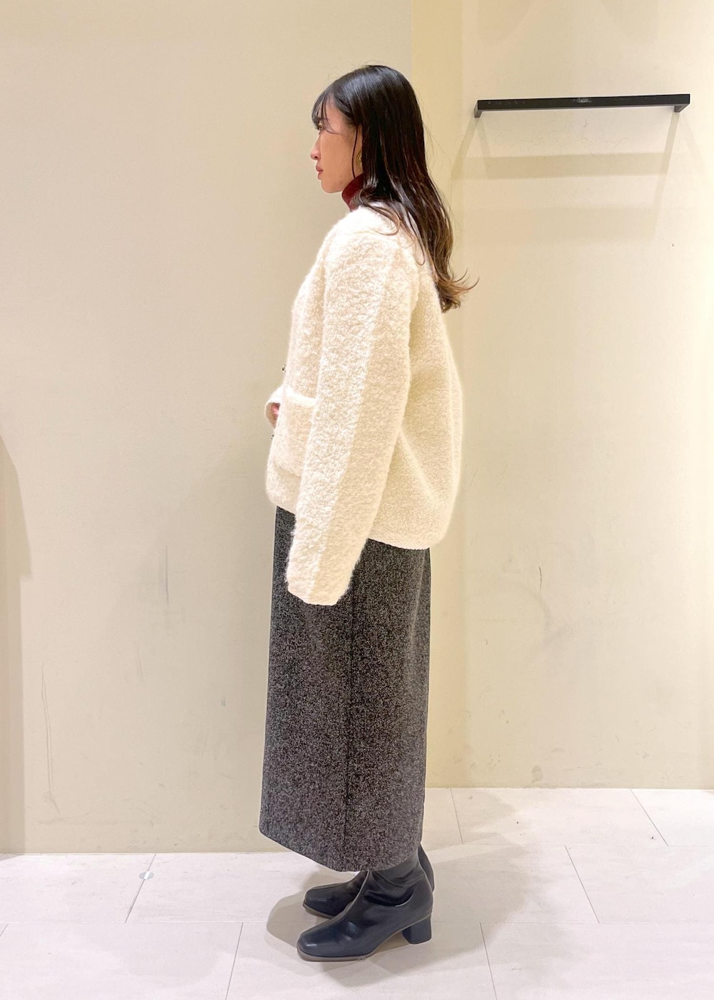 ブラック系のショルダーバッグ、ホワイト系のカーディガン/ボレロ、レッド系のニット/セーターを着用したレディースの秋コーディネートの4枚目の写真