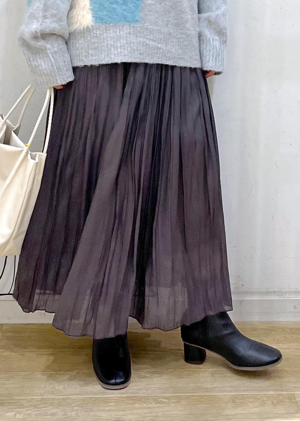 ブラック系のブーツ、ブルー系のニット/セーター、ブラウン系のスカートを着用したレディースの秋コーディネートの8枚目の写真