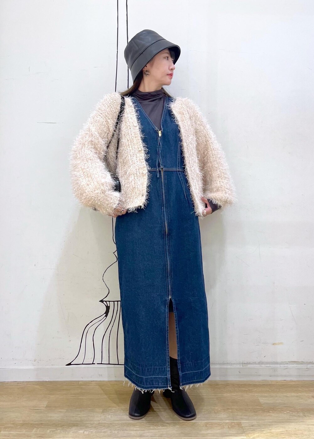 グレー系のTシャツ/カットソー、ベージュ系のカーディガン/ボレロ、ブラック系のブーツを着用したレディースの秋コーディネートの2枚目の写真