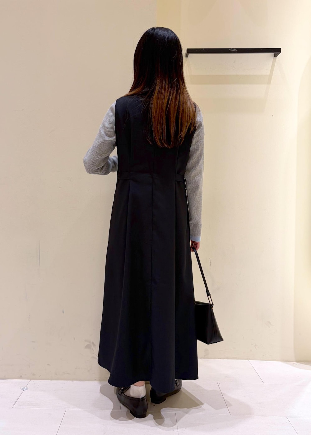 ブラック系のショルダーバッグ、ブラック系のローファー、グレー系のニット/セーターを着用したレディースの冬コーディネートの3枚目の写真