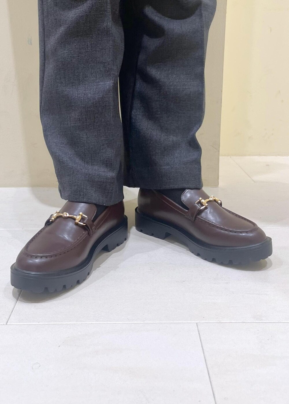 ホワイト系のニット/セーター、グレー系のスラックス、ブラウン系のローファーを着用したレディースの冬コーディネートの10枚目の写真