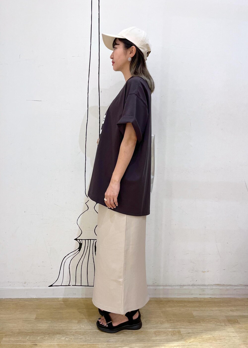 シルバー系のトートバッグ、ブラック系のサンダル、グレー系のTシャツ/カットソーを着用したレディースの夏コーディネートの3枚目の写真