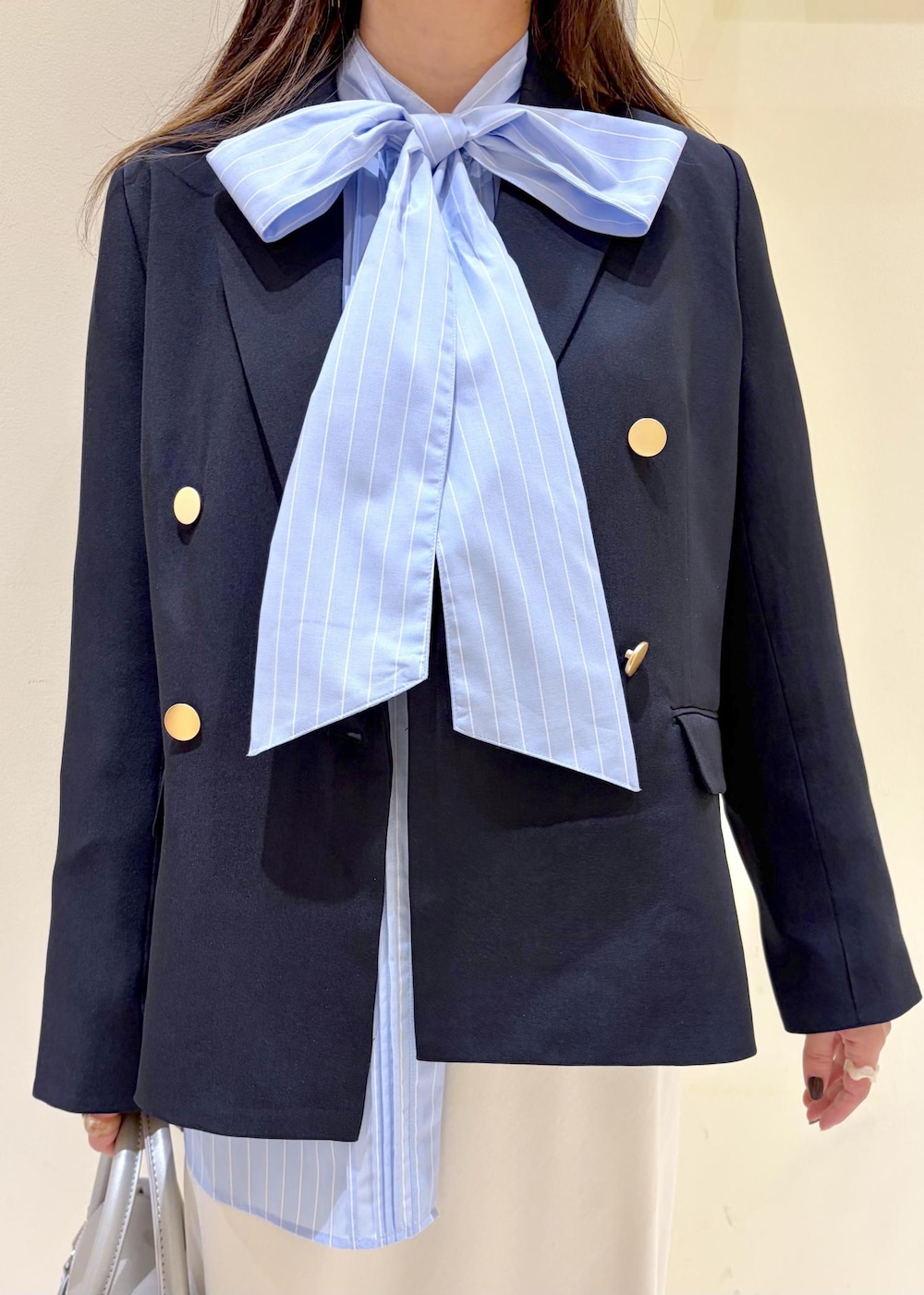 シルバー系のショルダーバッグ、ブルー系のテーラードジャケット、ブルー系のシャツ/ブラウスを着用したレディースの冬コーディネートの4枚目の写真