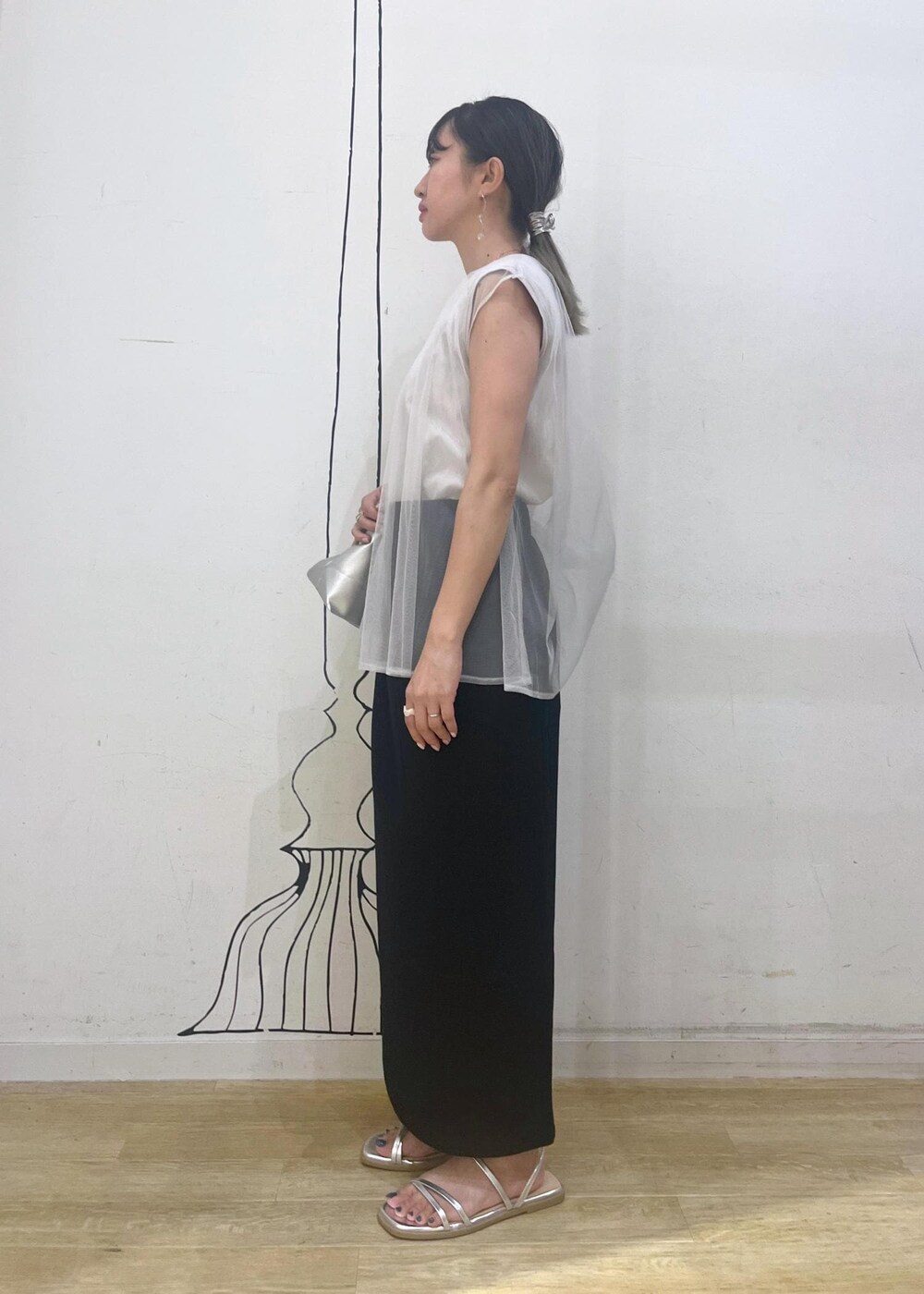 シルバー系のサンダル、ブラック系のスカート、シルバー系のトートバッグを着用したレディースの夏コーディネートの2枚目の写真