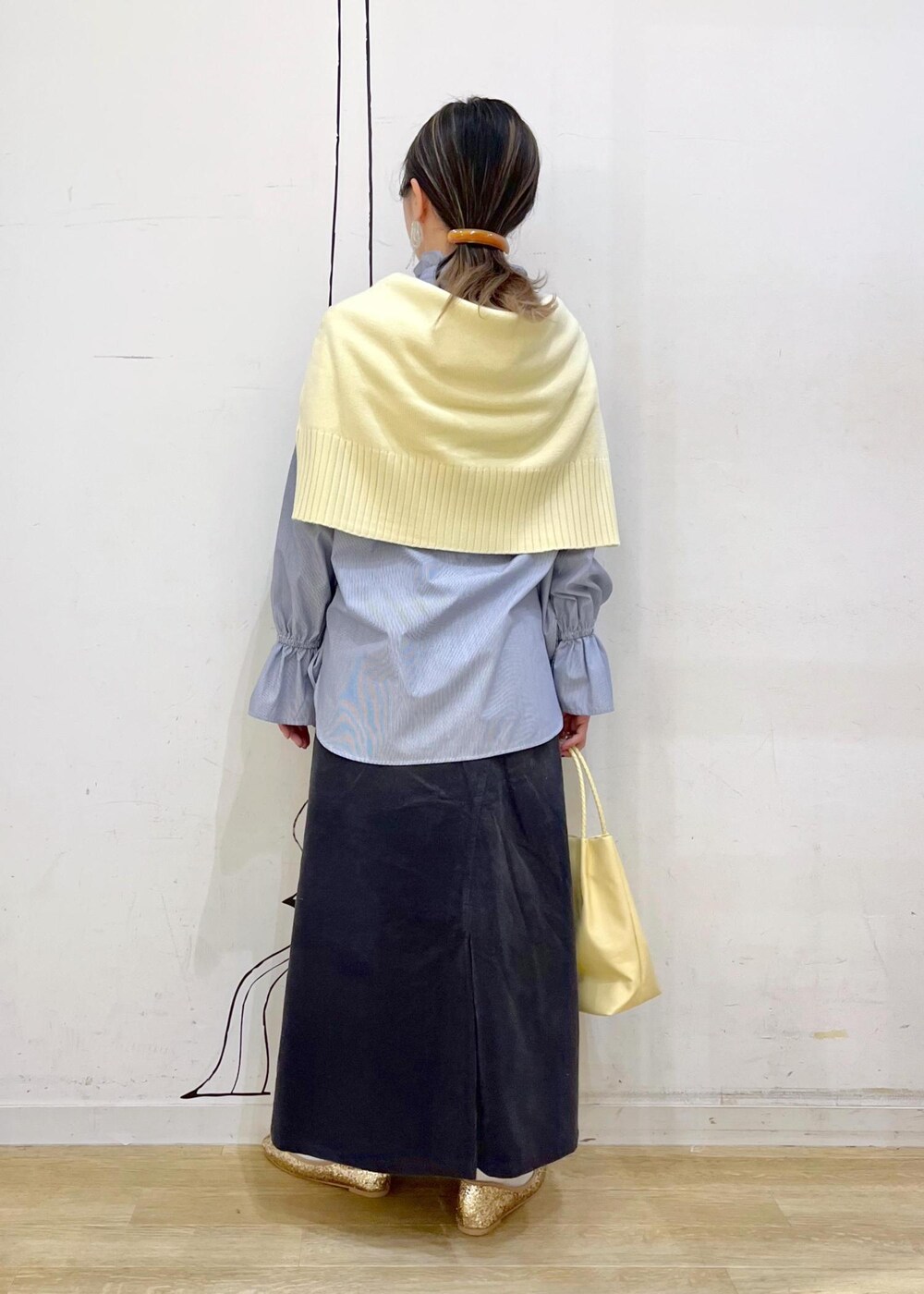 イエロー系のトートバッグ、グレー系のスカート、ブルー系のシャツ/ブラウスを着用したレディースの冬コーディネートの3枚目の写真