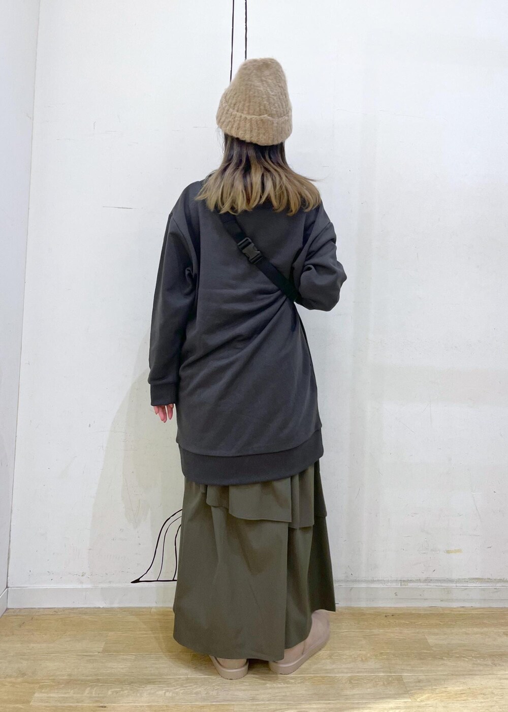 グリーン系のスカート、グレー系のワンピース、ホワイト系のボディバッグ/ウエストポーチを着用したレディースの秋コーディネートの5枚目の写真