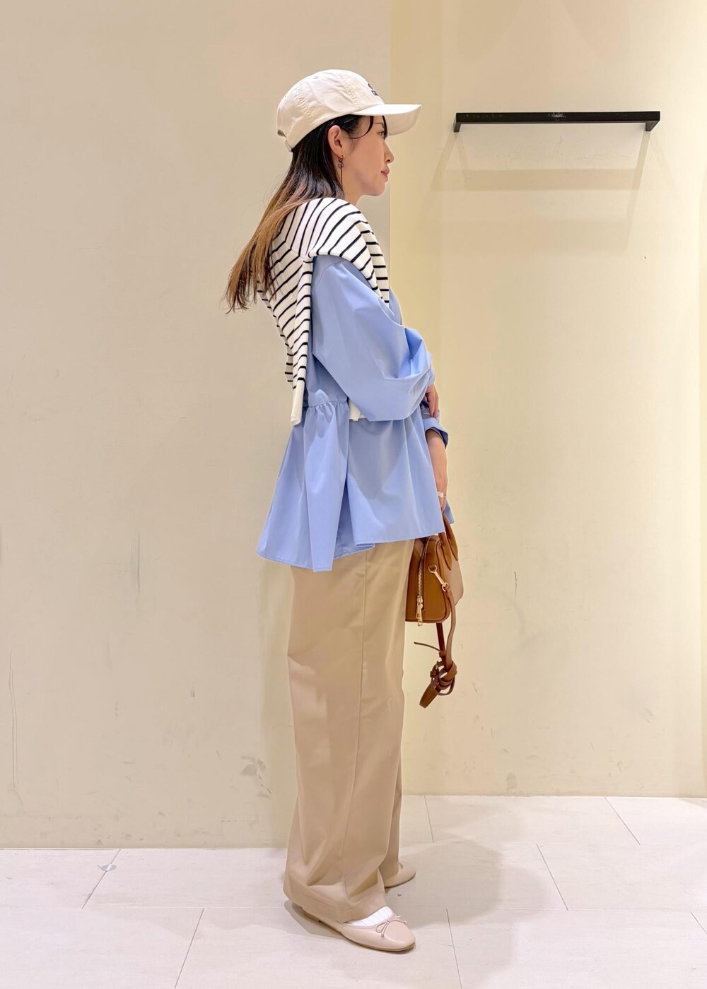 ホワイト系のバレエシューズ、イエロー系のショルダーバッグ、ベージュ系のチノパンツを着用したレディースの冬コーディネートの2枚目の写真