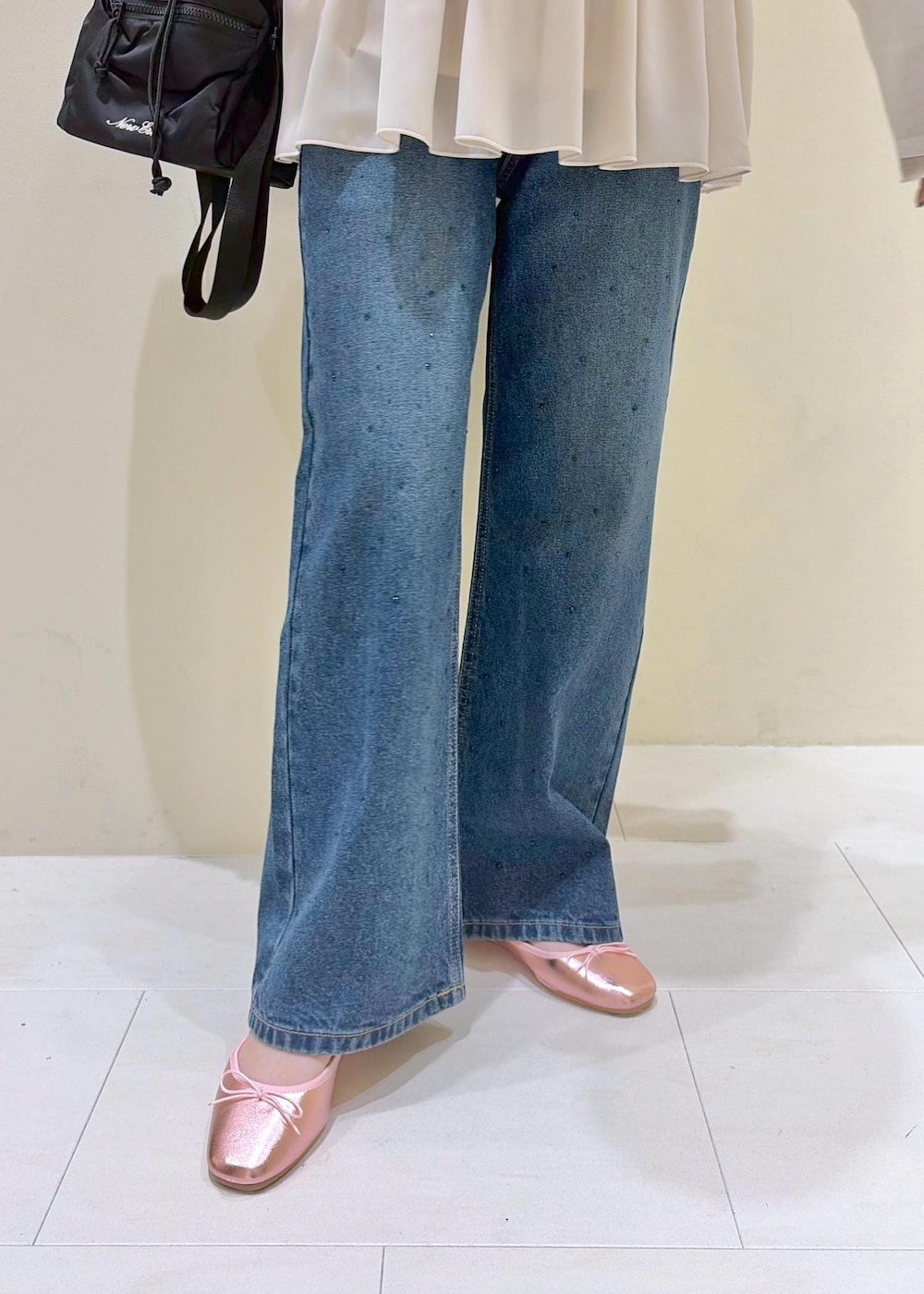 ブルー系のデニムパンツ、ベージュ系のTシャツ/カットソー、ピンク系のバレエシューズを着用したレディースの春コーディネートの8枚目の写真