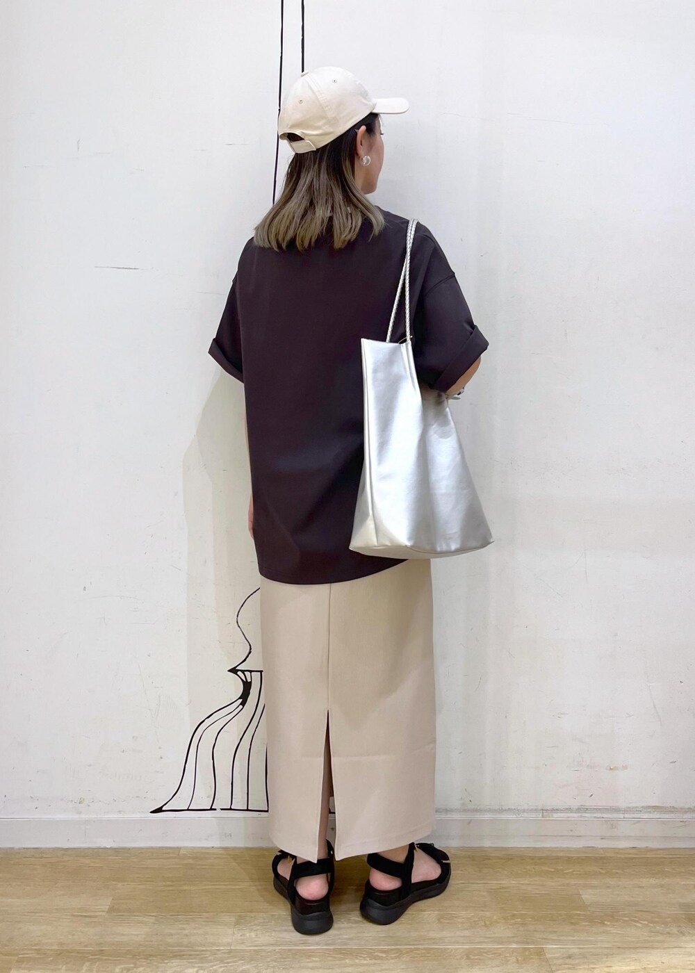 シルバー系のトートバッグ、ブラック系のサンダル、グレー系のTシャツ/カットソーを着用したレディースの夏コーディネートの4枚目の写真