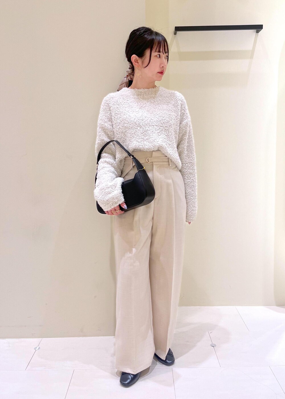 ブラック系のハンドバッグ、グレー系のニット/セーター、ブラック系のバレエシューズを着用したレディースの春コーディネートの3枚目の写真