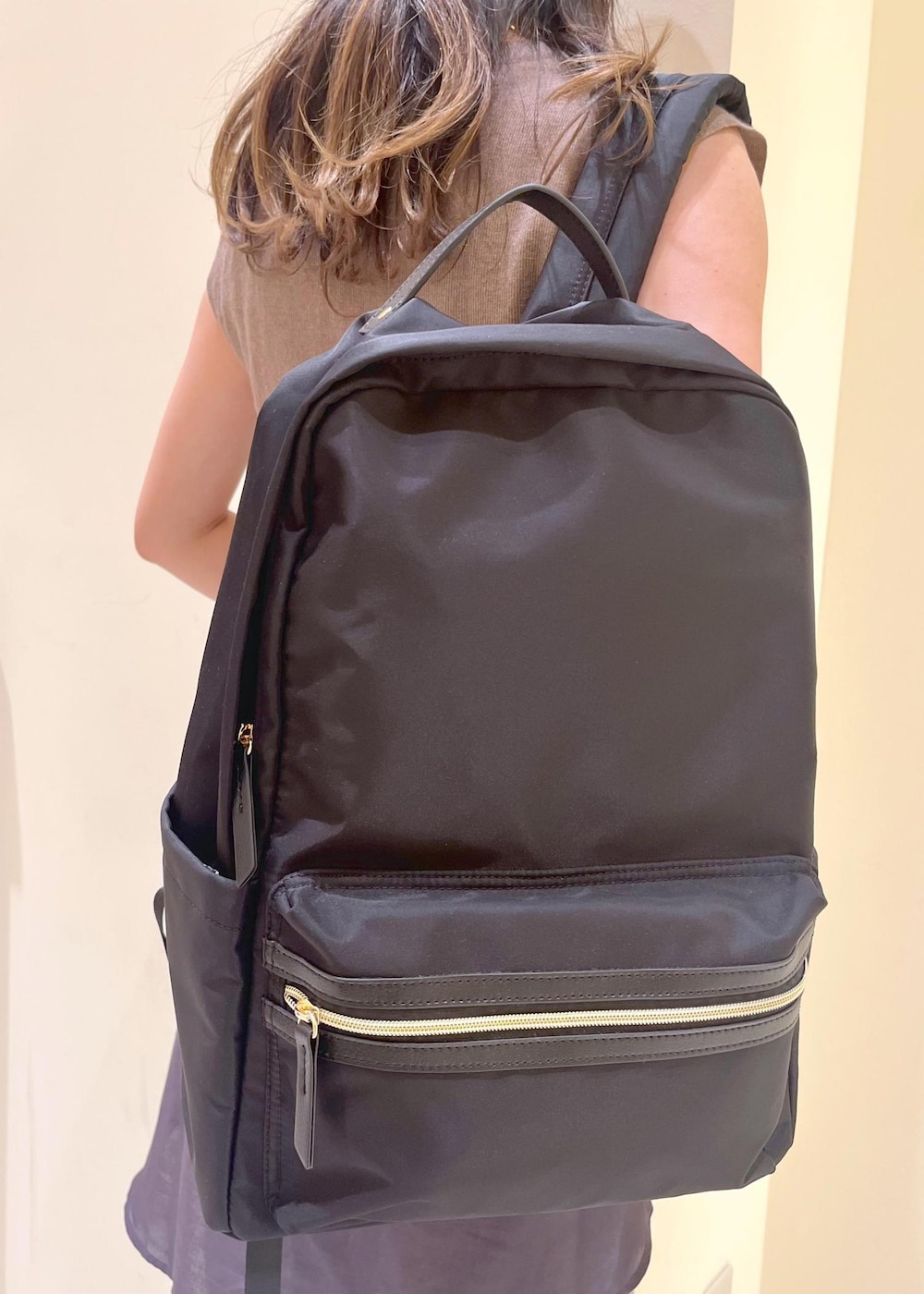 ブルー系のデニムパンツ、ブラック系のサンダル、ブラック系のバックパック/リュックを着用したレディースの夏コーディネートの9枚目の写真