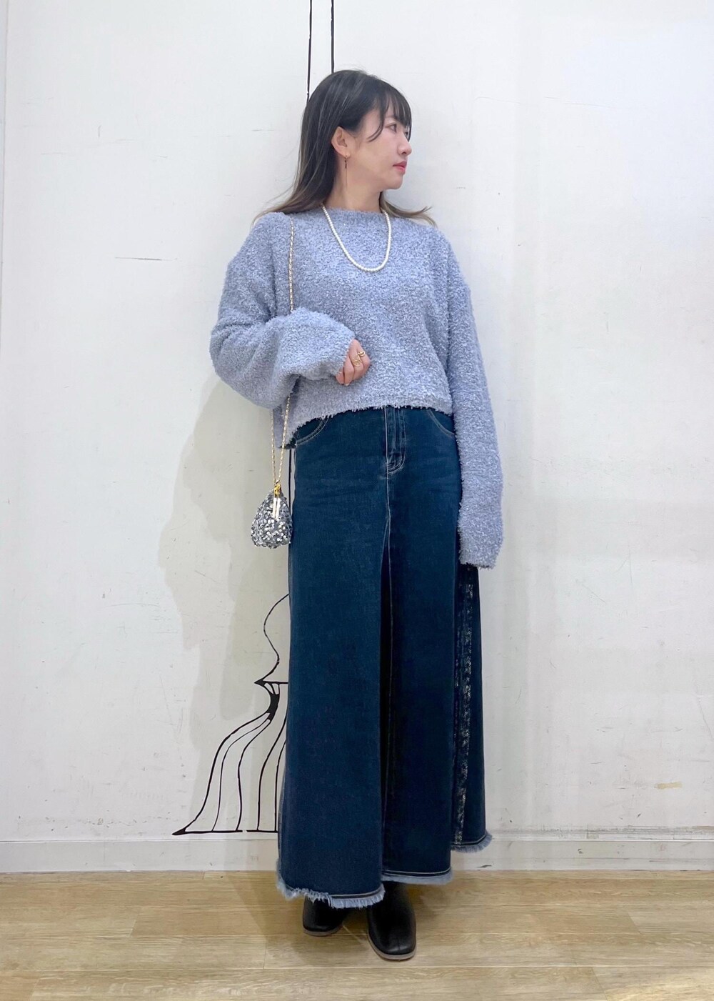 ブラック系のブーツ、グレー系のショルダーバッグ、ブルー系のデニムスカートを着用したレディースの冬コーディネートの3枚目の写真