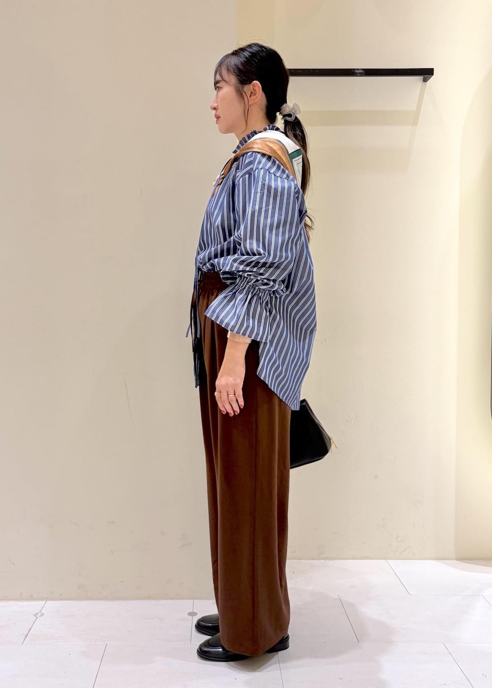 ブラウン系のその他パンツ、ブルー系のシャツ/ブラウス、ブラック系のローファーを着用したレディースの秋コーディネートの5枚目の写真