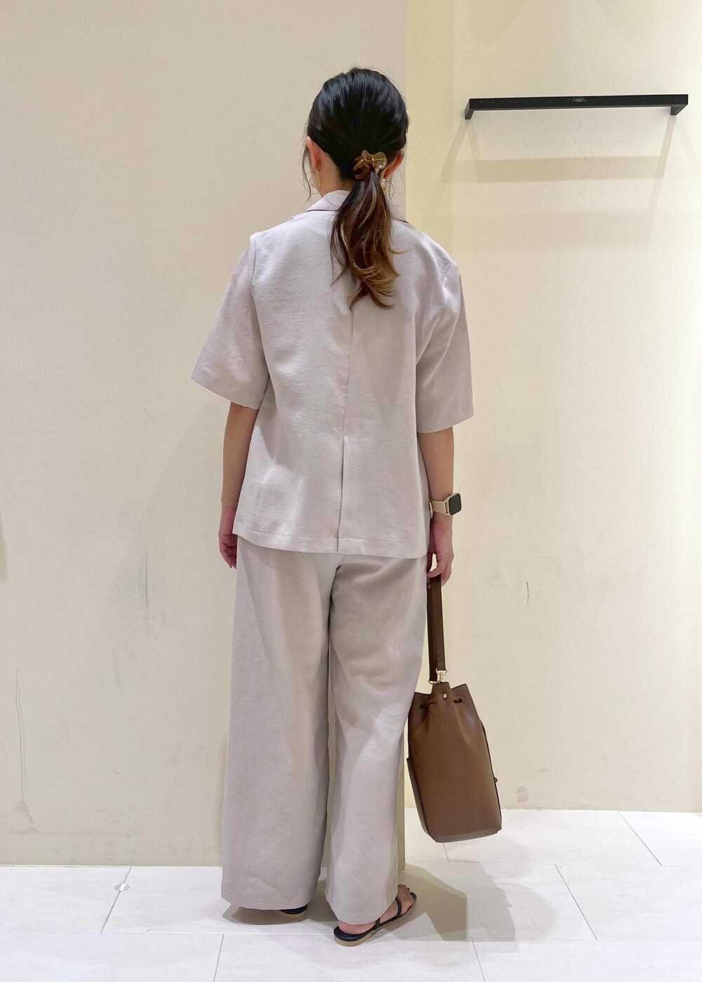 ベージュ系のテーラードジャケット、その他のニット/セーター、ブラウン系のショルダーバッグを着用したレディースの秋コーディネートの4枚目の写真