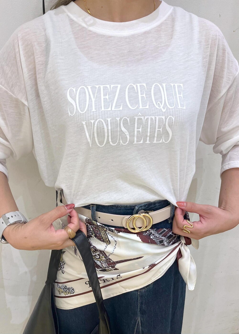 ブラック系のパンプス、ブラック系のトートバッグ、ブルー系のデニムスカートを着用したレディースの秋コーディネートの5枚目の写真