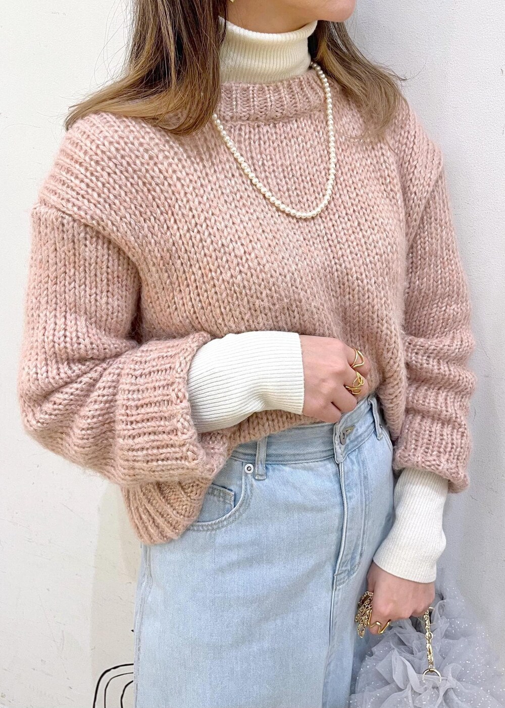 ホワイト系のニット/セーター、ブラック系のパンプス、ブルー系のデニムスカートを着用したレディースの冬コーディネートの6枚目の写真