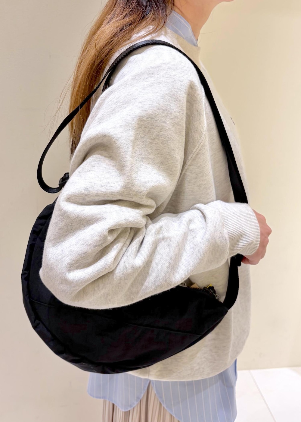 ホワイト系のスウェット、ブルー系のシャツ/ブラウス、ベージュ系のスカートを着用したレディースの冬コーディネートの7枚目の写真