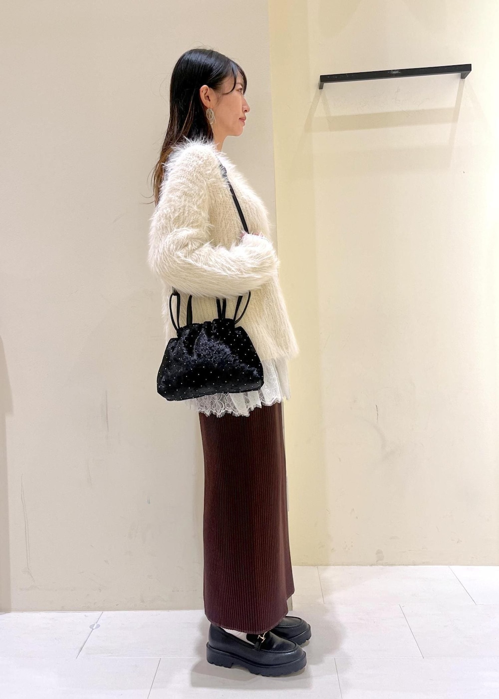 ホワイト系のTシャツ/カットソー、ブラック系のローファー、ブラック系のハンドバッグを着用したレディースの冬コーディネートの2枚目の写真