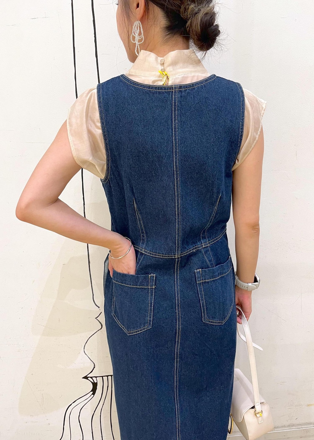 グレー系のタンクトップ、ブラック系のパンプス、ホワイト系のショルダーバッグを着用したレディースの夏コーディネートの6枚目の写真