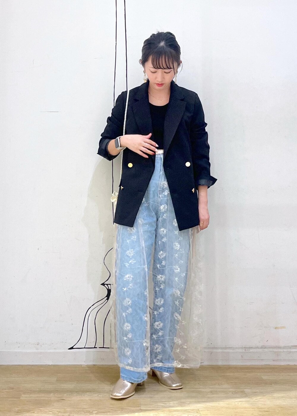 ホワイト系のスカート、ブラック系のニット/セーター、ブラック系のテーラードジャケットを着用したレディースの秋コーディネートの3枚目の写真