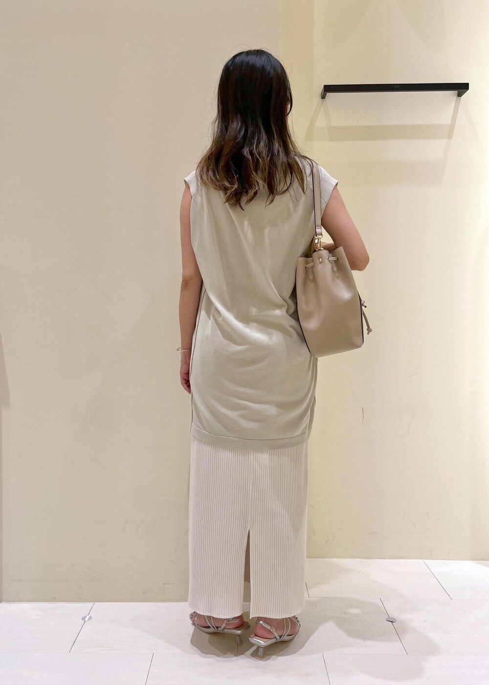 ベージュ系のタンクトップ、シルバー系のサンダル、ベージュ系のショルダーバッグを着用したレディースの夏コーディネートの4枚目の写真