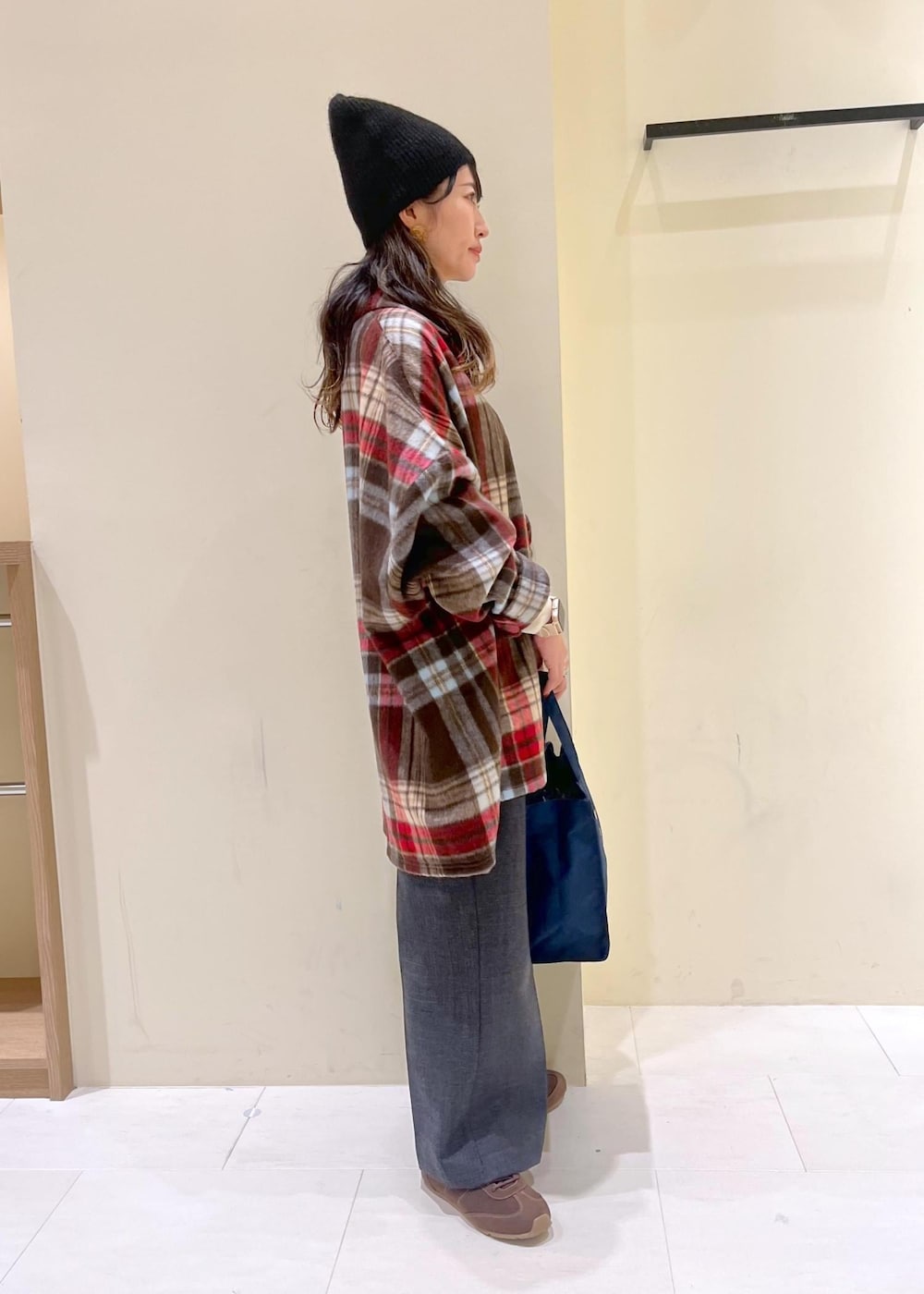 ブラウン系のシャツ/ブラウス、ホワイト系のニット/セーター、グレー系のスラックスを着用したレディースの冬コーディネートの3枚目の写真