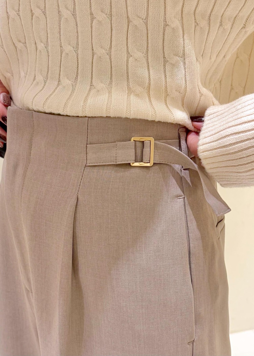 ホワイト系のニット/セーター、ベージュ系のその他パンツ、ブラック系のボディバッグ/ウエストポーチを着用したレディースの冬コーディネートの6枚目の写真