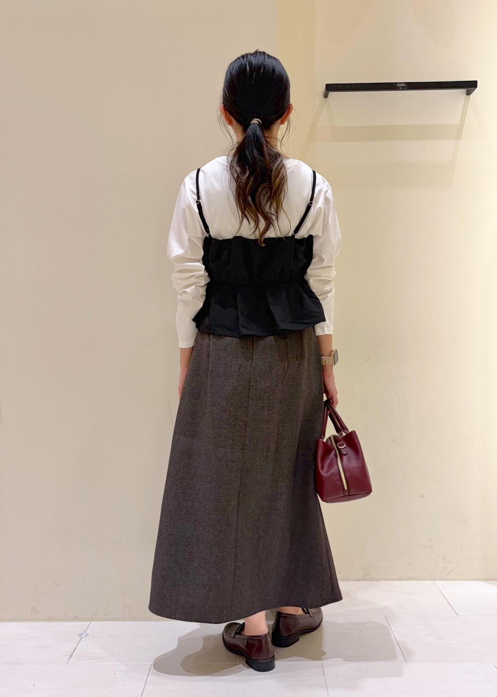 ブラウン系のスカート、ホワイト系のTシャツ/カットソー、ブラック系のキャミソールを着用したレディースの秋コーディネートの3枚目の写真