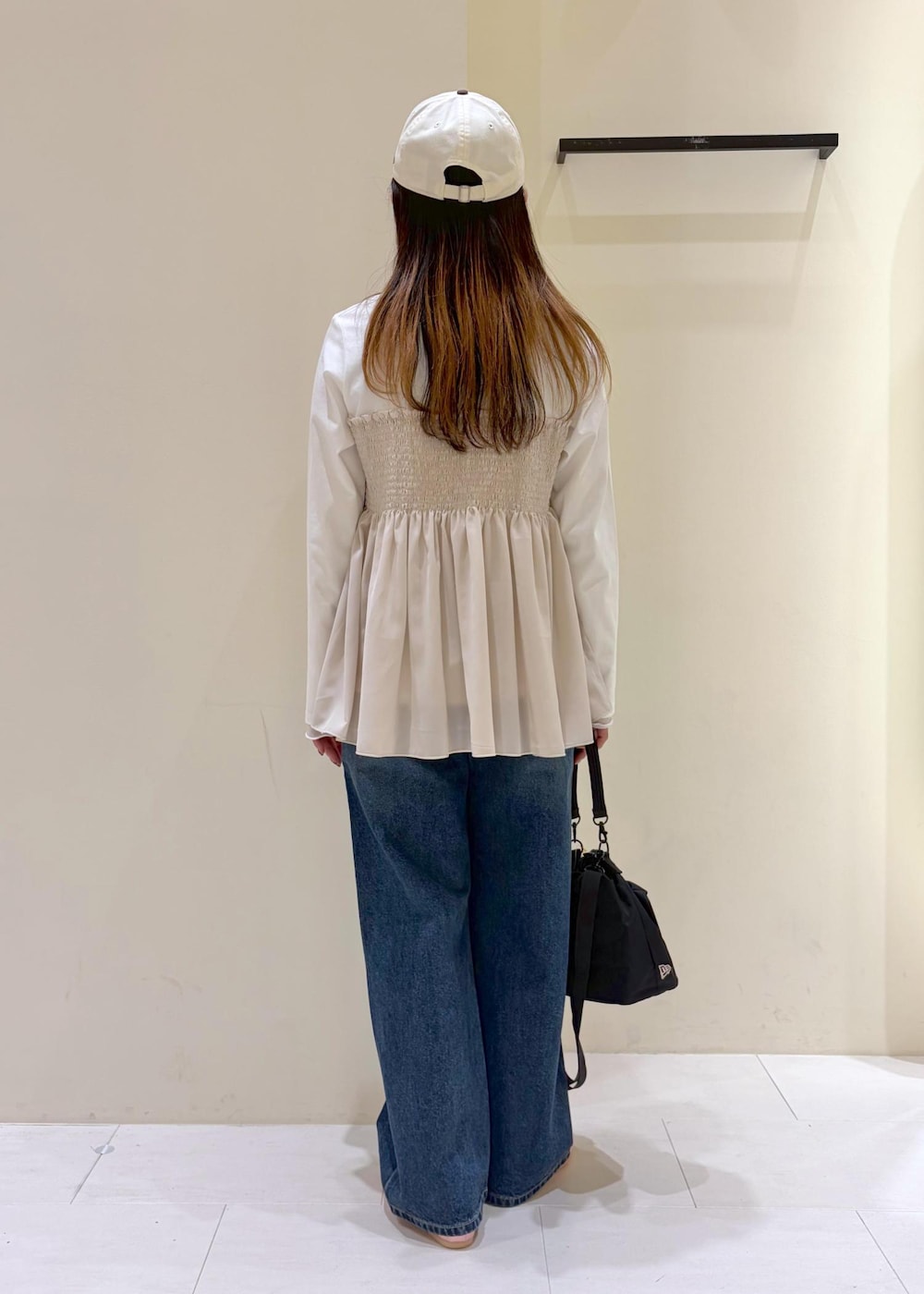 ブルー系のデニムパンツ、ベージュ系のTシャツ/カットソー、ピンク系のバレエシューズを着用したレディースの春コーディネートの3枚目の写真