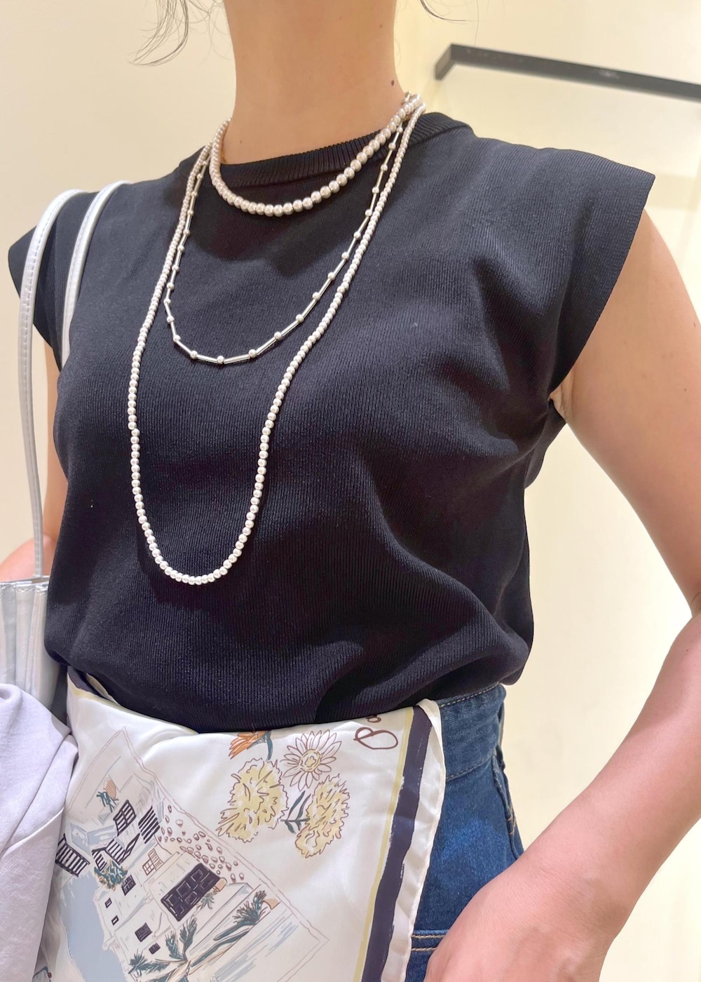 ブルー系のデニムパンツ、シルバー系のトートバッグ、ブラック系のパンプスを着用したレディースの夏コーディネートの5枚目の写真