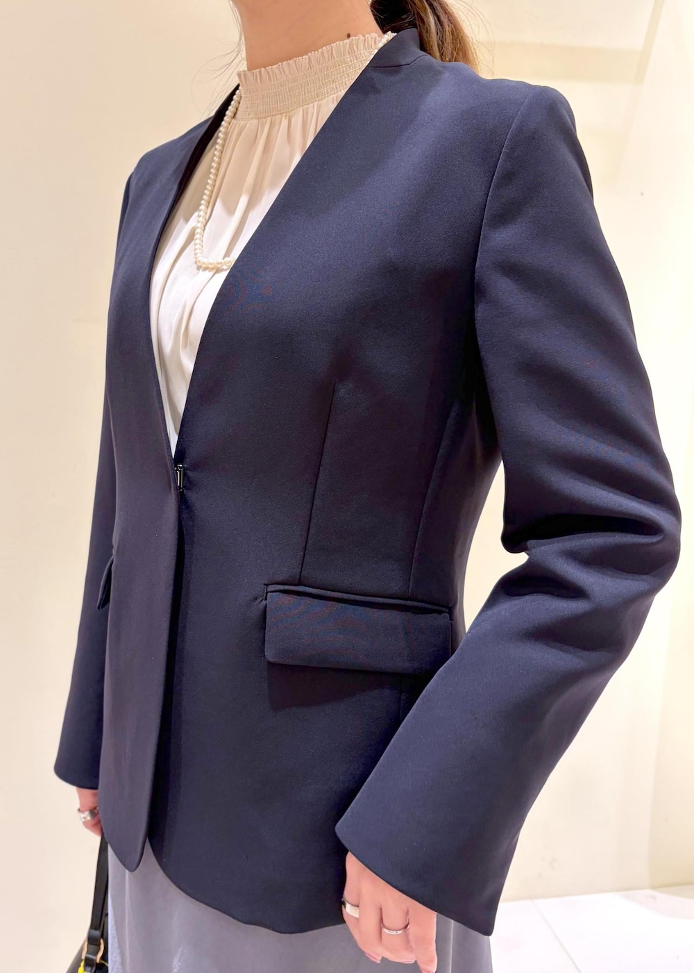 ホワイト系のシャツ/ブラウス、ブルー系のノーカラージャケット、ブラック系のショルダーバッグを着用したレディースの冬コーディネートの5枚目の写真