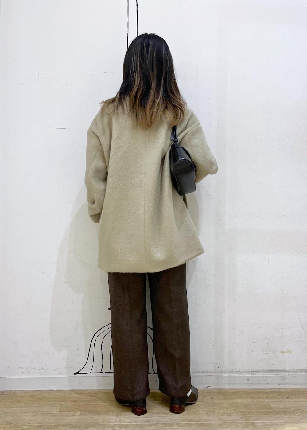 ホワイト系のニット/セーター、グリーン系のその他アウター、ブラウン系のその他パンツを着用したレディースの冬コーディネートの9枚目の写真