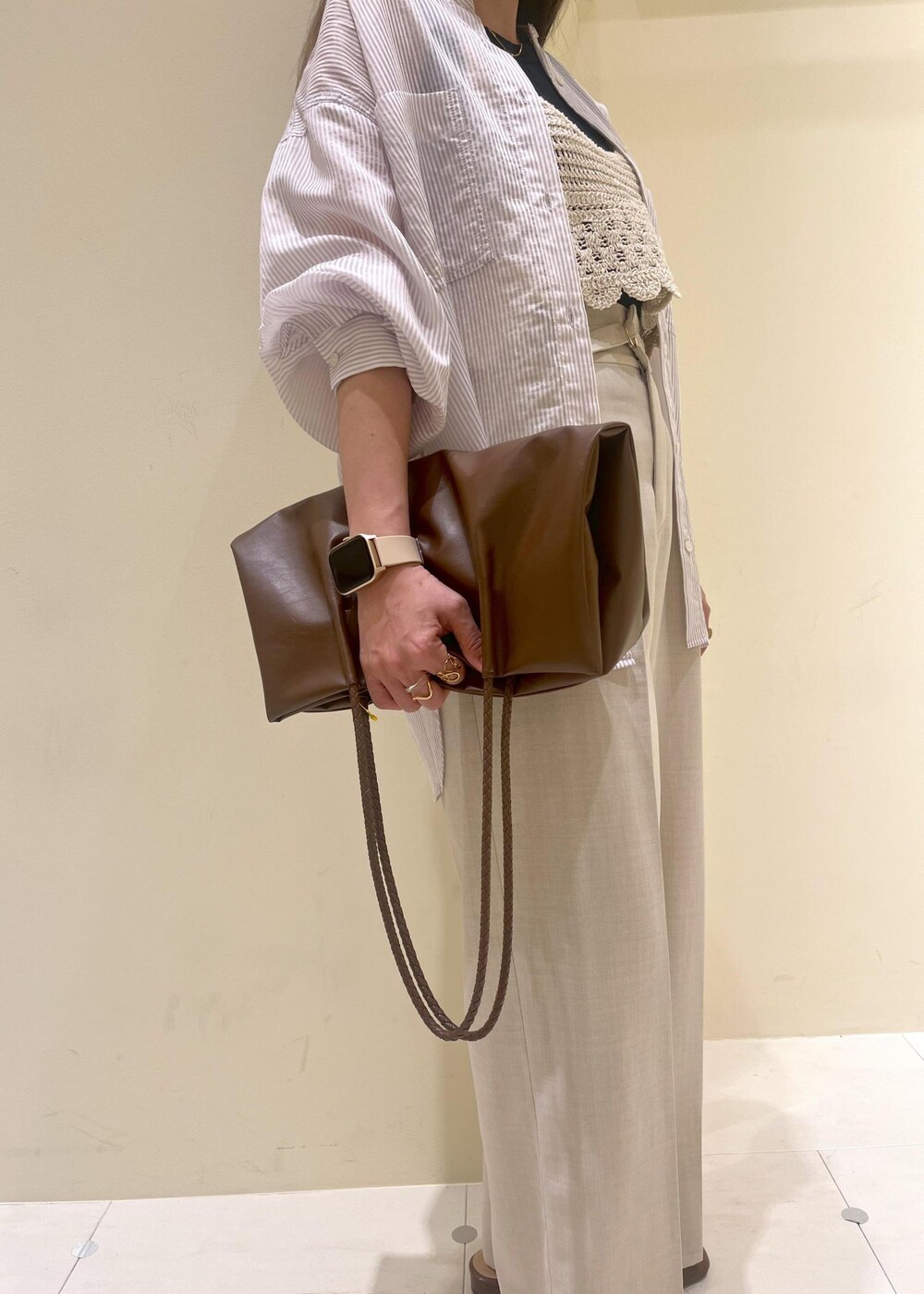 ブラック系のタンクトップ、ブラウン系のトートバッグ、イエロー系のローファーを着用したレディースの春コーディネートの8枚目の写真