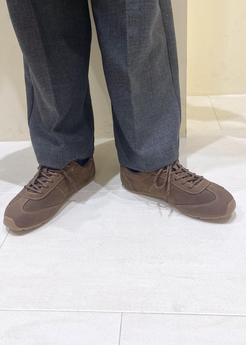 ブラウン系のシャツ/ブラウス、ホワイト系のニット/セーター、グレー系のスラックスを着用したレディースの冬コーディネートの9枚目の写真