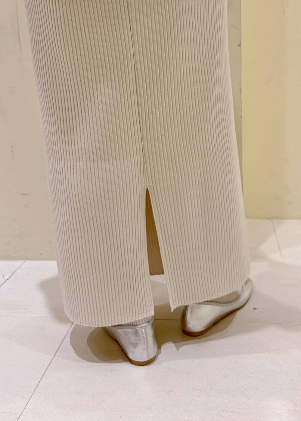 シルバー系のバレエシューズ、ホワイト系のシャツ/ブラウス、イエロー系のニット/セーターを着用したレディースの冬コーディネートの8枚目の写真