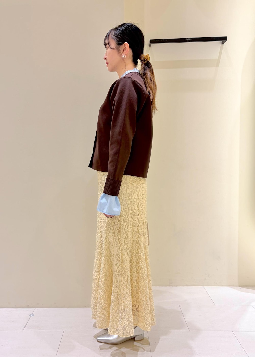 ホワイト系のボストンバッグ、ベージュ系のスカート、ブラウン系のカーディガン/ボレロを着用したレディースの春コーディネートの4枚目の写真