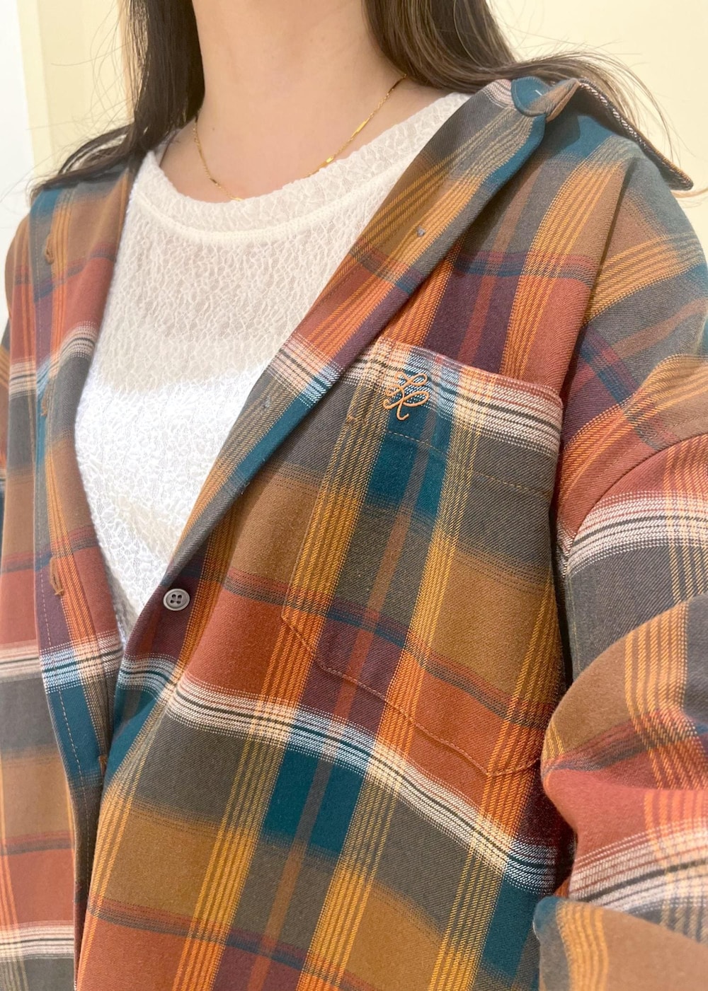 ブルー系のスカート、オレンジ系のシャツ/ブラウス、ホワイト系のTシャツ/カットソーを着用したレディースの秋コーディネートの5枚目の写真