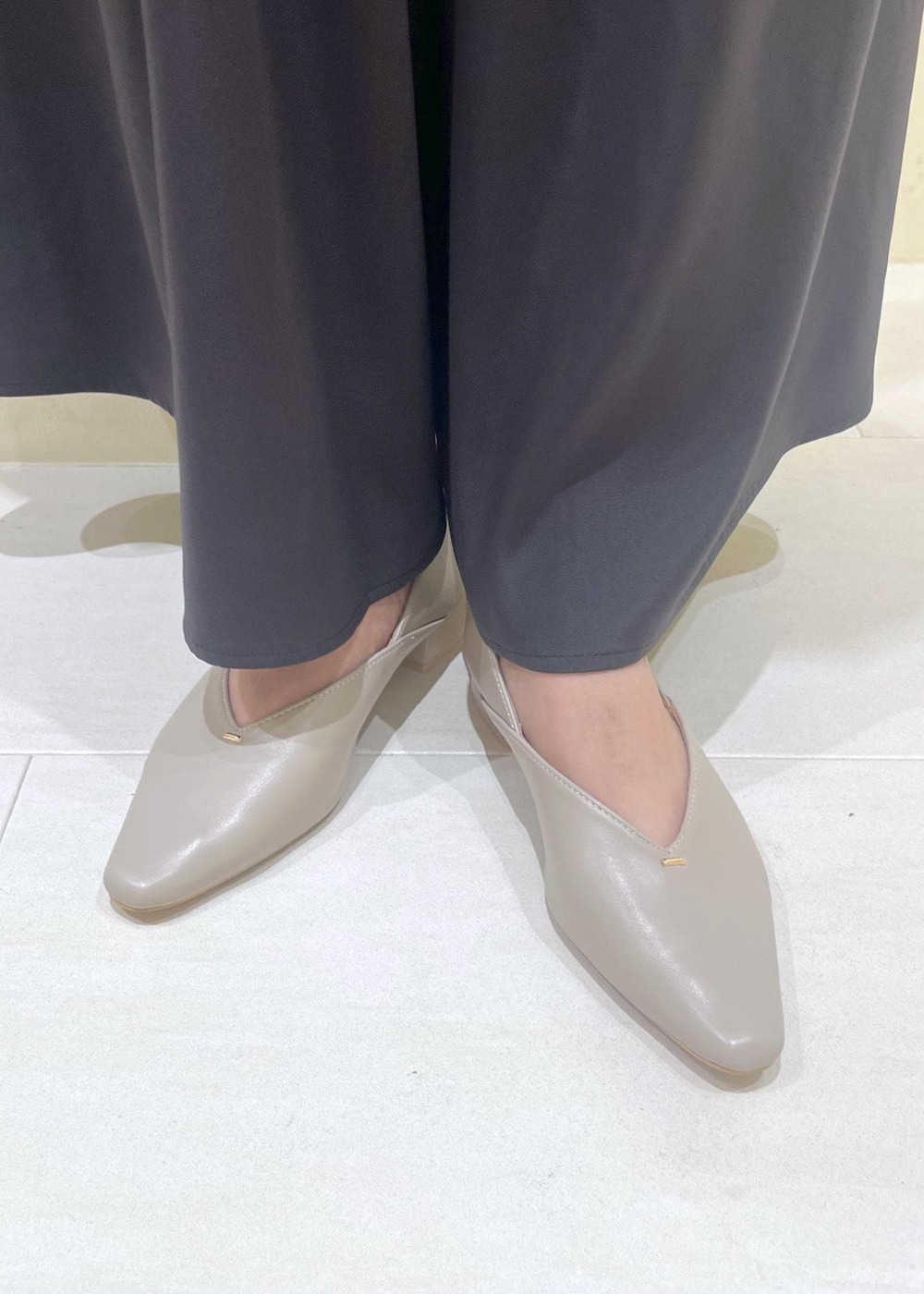 レッド系のショルダーバッグ、ベージュ系のパンプス、ベージュ系のカーディガン/ボレロを着用したレディースの秋コーディネートの10枚目の写真