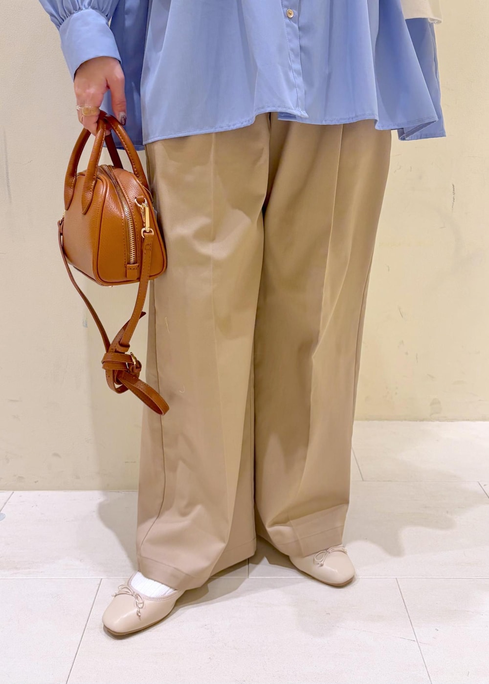 ホワイト系のバレエシューズ、イエロー系のショルダーバッグ、ベージュ系のチノパンツを着用したレディースの冬コーディネートの8枚目の写真